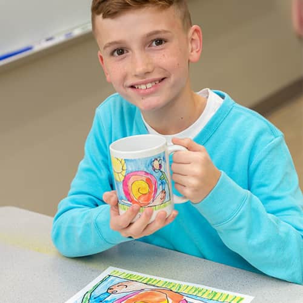 Incorporate an Art Fundraiser for Schools from Art to Remember image shows kid holding up mug